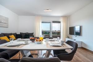 ein Esszimmer mit Tisch, Stühlen und Fernseher in der Unterkunft Villa Dalmata in Trogir