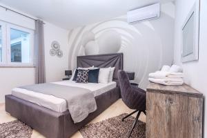 Un dormitorio con una cama y una silla dentro. en Villa Matan - only 200m from the sandy beaches, private 28m2 pool, en Omiš 43 fotos más