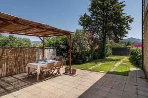 un tavolo e sedie sotto un pergolato su un patio di Capitana Rooms a Costa degli Angeli