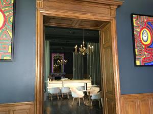 a dining room with a table and chairs and a mirror at Hôtel de France in Auch