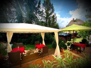 a patio with red tables and a yellow umbrella at Apartment Heidi in Oberasbach