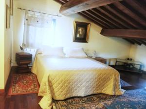 a bedroom with a large bed with a yellow blanket at B&B Il Casolare Di Bonci in Santa Maria a Monte