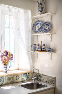 una cucina con piatti blu e bianchi e un lavandino di CASA DA AVO by Ammonite&Co a Olhão