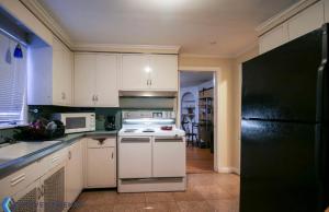 a kitchen with white cabinets and a black refrigerator at Town Plot Waterbury in Waterbury