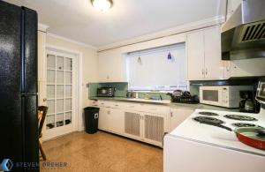 a kitchen with white cabinets and a white stove top oven at Town Plot Waterbury in Waterbury