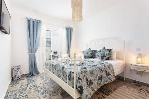 una camera da letto con un letto e una finestra con tende blu di CASA DA AVO by Ammonite&Co a Olhão