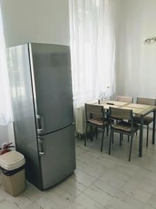 eine Küche mit einem Kühlschrank aus Edelstahl und einem Tisch in der Unterkunft Apartman na namesti in Opočno