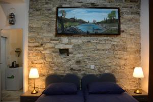 a living room with a tv on a stone wall at Lazaros Stonehouse in Pano Lefkara