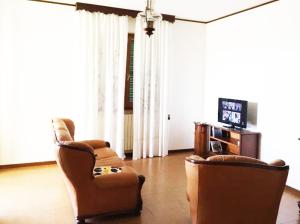 a living room with two chairs and a television at La Collina di Emma in Massignano