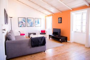 a living room with a couch and a tv at Apartamento Joaquim Tello in Lagos
