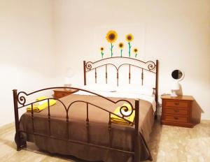a bedroom with a bed with sunflowers on the wall at La Collina di Emma in Massignano +9 photos