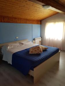 a bedroom with a bed with blue sheets and a window at Appartamenti Bice Abetone in Abetone