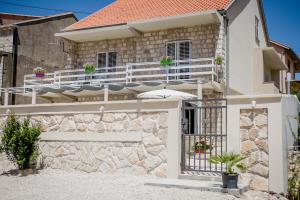 a house with a balcony with an umbrella at Villa Branka apartments near Dubrovnik with Pool in Ivanica