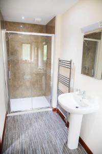 uma casa de banho com um lavatório e um chuveiro em Ardennan House Hotel em Inverurie