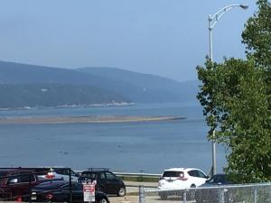 a parking lot with cars parked next to the water at Petit Hôtel Amara in La Malbaie