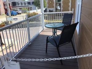 une terrasse couverte avec une table et une chaise. dans l'établissement Petit Hôtel Amara, à La Malbaie