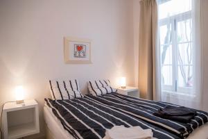 a bedroom with a bed with two lamps on two tables at Apartamento Joaquim Tello in Lagos