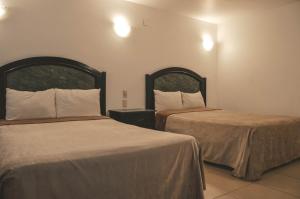 Un pat sau paturi într-o cameră la Hotel Latino