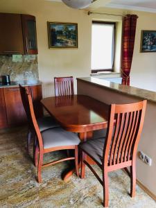 a kitchen with a wooden table and chairs at Apartament Plumeria in Zakopane