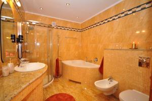 a bathroom with a tub and a sink and a toilet at Apartament Plumeria in Zakopane