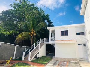 una casa blanca con una escalera delante en Paradis Caraïbes, en Sainte-Anne