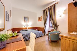 una camera d'albergo con letto e scrivania di Hotel Gea Di Vulcano a Roma
