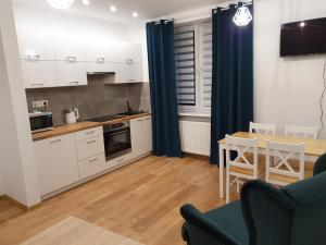 a kitchen and dining room with white cabinets and a table at Apartament Aga in Ustrzyki Dolne