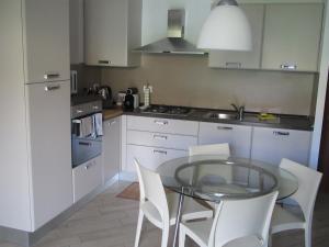 a kitchen with a glass table and white cabinets at A VERONA DA PAOLO & ELENA in Verona