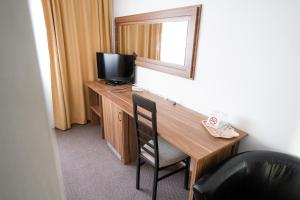 a room with a desk with a television and a mirror at Hotel Polaris in Suceava