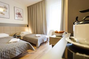 a hotel room with two beds and a table at Wolska Residence in Warsaw