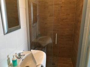 uma casa de banho com um chuveiro e um lavatório. em Apartments Zara em Zadar