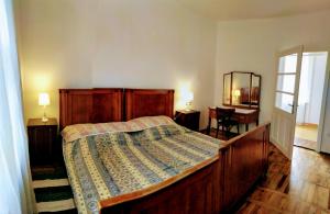1 dormitorio con cama de madera y espejo en Bubics Porta, en Kétbodony