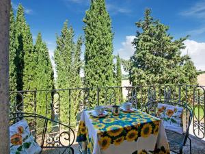 einen Tisch und Stühle auf einem Balkon mit Bäumen in der Unterkunft Belvilla by OYO Casale Nuovo in Chianciano Terme