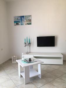 salon z białym stołem i telewizorem w obiekcie Gavran Apartment Vinjerac w mieście Vinjerac