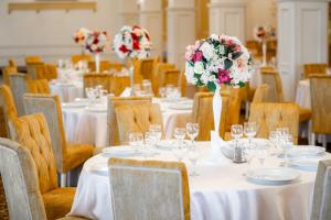 a dining room with tables and chairs with flowers on them at Hotel Polaris in Suceava