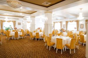 a banquet hall with tables and chairs and a room with windows at Hotel Polaris in Suceava