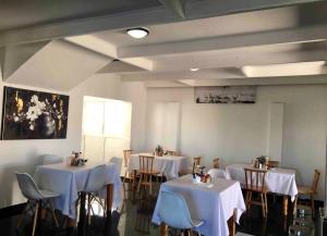 a room with tables and chairs with white table cloth at White House lodge in Mthatha