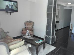 ein Wohnzimmer mit einem Sofa und einem Tisch in der Unterkunft White House lodge in Mthatha