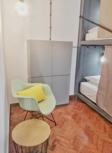 um quarto com uma cadeira e uma cama em Draft Hostel & Rooms em Lisboa