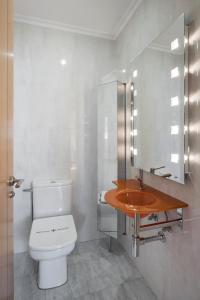 a bathroom with a white toilet and a sink at Atico en Santa Catalina in A Coruña