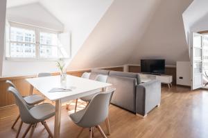 ein Wohnzimmer mit einem Tisch, Stühlen und einem Sofa in der Unterkunft Atico en Santa Catalina in A Coruña