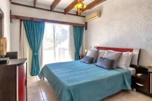 a bedroom with a blue bed with a large window at Lygaria Seaview Home in Lygaria