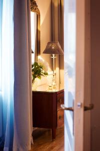 a dresser with a lamp and a mirror at Grand Hotell Hörnan in Uppsala