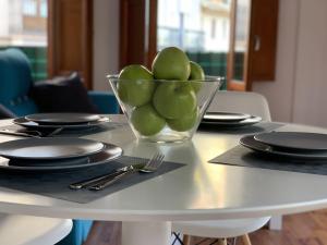 una ciotola di mele verdi su un tavolo con piatti di 123rooms a Valencia