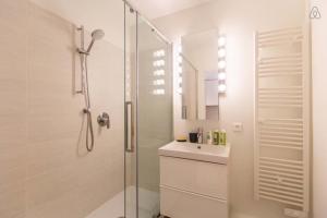 a white bathroom with a shower and a sink at CENTRE PROMENADE With terrace next to the sea in the pedestrian area in Nice