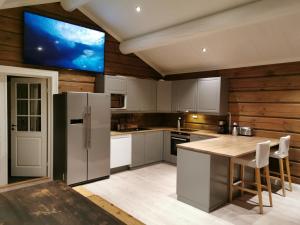a kitchen with a stainless steel refrigerator and a table at STORHAUGEN GARD in Lom