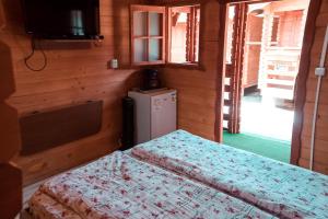 a small room with two beds and a refrigerator at Casutele Deny Băile Figa cu aer condiționat in Beclean +101 photos
