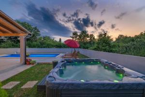 a hot tub in a backyard with a pool at Villa Blaise in Manjadvorci