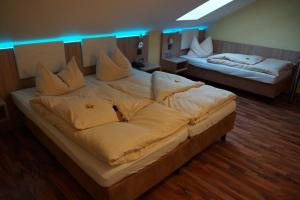 um quarto com 2 camas e almofadas brancas em Hotel garni Kleindienst em Ursensollen