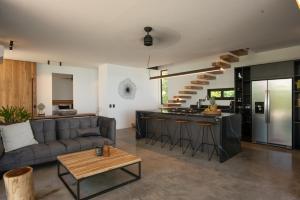 a living room and kitchen with a couch and a table at Villa Nof Yam in Santa Teresa Beach